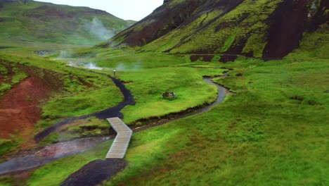 Río-Angosto-En-Medio-De-La-Pradera-Verde-En-El-Valle-De-Reykjadalur-En-El-Sur-De-Islandia