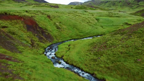 Scenery-Of-Rocky-River-With-Tourist-Walking-Along-The-Bank-In-The-Valley-Of-Reykjadalur,-Iceland