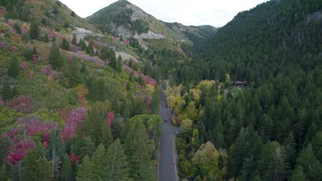 Car-driving-on-long-straight-panoramic-road-across-colorful-woodlands-in-Wasatch-Mountains,-Utah