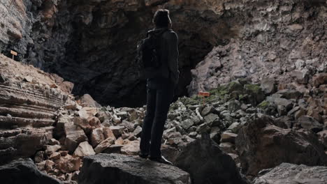 Man-stands-in-ancient-lava-tube-cave-in-El-Malpais-National-Monument-NM