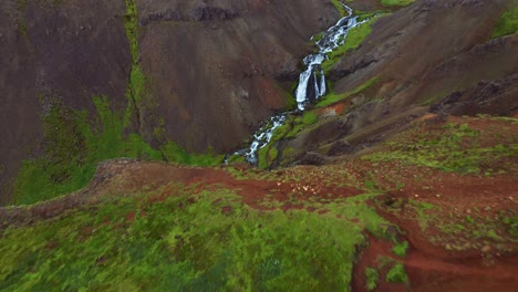 Flyover-Steep-Mountains-With-River-Stream-At-Reykjadalur-Valley-In-Iceland