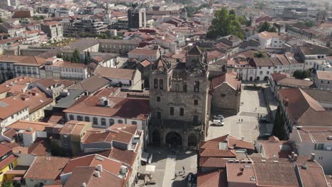 Aerial-parallax-motion-Old-Stone-Cathedral,-Surrounded-by-red-rooftops---Braga-City-Centre