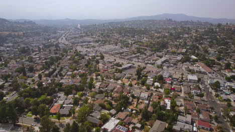 Flyover-Eagle-Rock-neighborhood-and-towards-highway-in-Los-Angeles,-California-on-a-beautiful-summer-day
