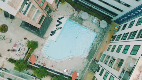Unique-drone-footage-offering-a-look-at-a-pool-and-patio-inside-a-large-apartment-complex