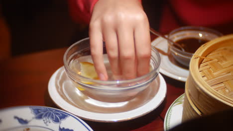 Ein-Mädchen-Benutzt-In-Einem-Chinesischen-Restaurant-Einen-Wasserfingerdarm-Mit-Zitrone