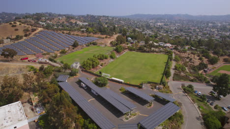 Pull-away-from-solar-panels-and-soccer-field-on-a-college-campus-in-Los-Angeles,-California-on-a-pretty-summer-day