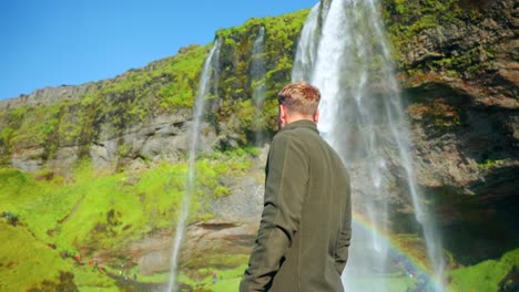 Hombre-Caucásico-Frente-A-Las-Impresionantes-Cascadas-De-Seljalandsfoss-En-El-Sur-De-Islandia
