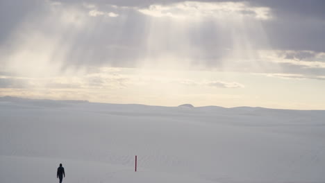 Schöne-Sonnenaufgang-Lichtstrahlen-In-White-Sands-New-Mexico-Mit-Wanderer-In-Sanddünen