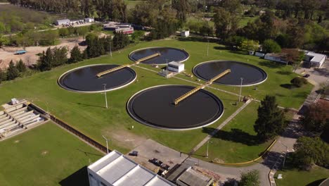 Aerial-flyover-water-purification-plant-during-sunny-day-in-Buenos-Aires---Filtration-Of-Dirty-Water-in-circular-pools