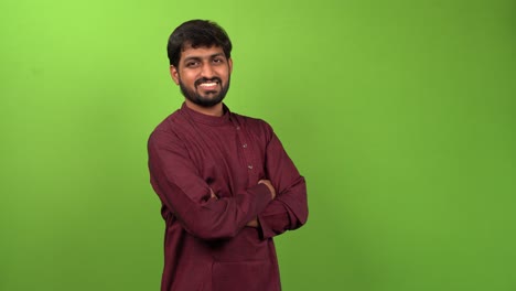 Attractive-young-man-watching-towards-camera-with-crossed-arms,-isolated-green-screen
