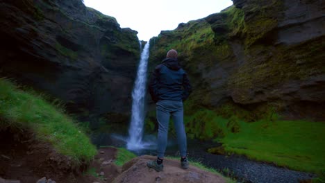 El-Turista-Visita-La-Cascada-Kvernufoss-Con-Un-Amplio-Desfiladero-Rocoso-En-El-Sur-De-Islandia