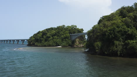 Versunkene-Yacht-An-Der-Küste-Von-Samana-Mit-Blick-Auf-Die-Brücke-Von-Nirgendwo-In-Der-Dominikanischen-Republik---Luftaufnahme