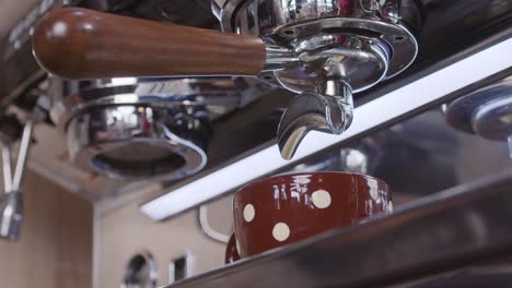 Slow-motion-closeup-of-a-modern-industrial-coffee-maker-in-a-coffee-shop-pouring-coffee-in-a-cup