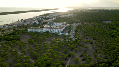 Luftaufnahme-Des-Luxuriösen-Gartenhotels-Playanatural-In-El-Rompido-Bei-Sonnenuntergang-Im-Hintergrund,-Spanien