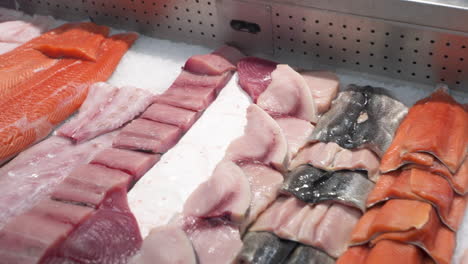 Various-cuts-of-seafood-in-fish-market-display-case,-slider-HD