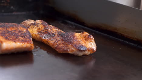 Blackened-salmon-and-tilapia-sizzle-on-flat-top-griddle,-seasoned-fish-sears-on-griddle,-HD