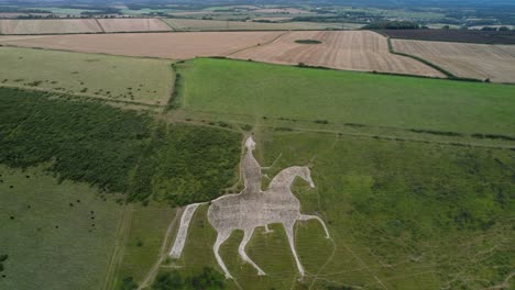 Osmington-White-Horse-limestone-chalk-hillside-countryside-art-attraction-aerial-view-pull-back-reveal
