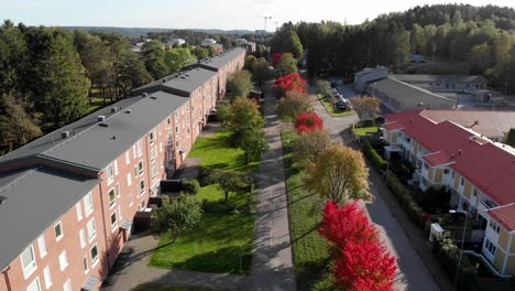Terraced-Row-of-Houses-Surrounded-by-Red-Trees-in-Autumn,-Aerial-View