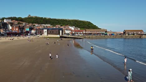 Aerial-view-of-beach-during-summertime-revealing-blue-sky-and-calm-sea-Scarborough-England-UK