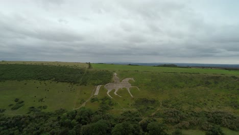 Osmington-White-Horse-legendary-chalk-figure-art-on-hillside-slope-aerial-view-rising-above-countryside
