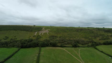 Osmington-White-Horse-limestone-figure-sculpture-on-hillside-farmland-aerial-view-low-orbit-right