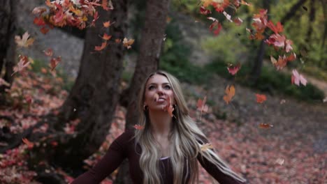 Slow-Motion-Of-Happy-Young-Woman-Throwing-Autumn-Leaves-Into-The-Air