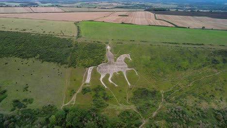 Osmington-White-Horse-historical-chalk-figure-art-on-hillside-slope-aerial-view-push-in-tilt-down