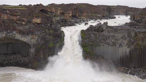 Wide-shot-of-giant-Aldeyjarfoss-with-powerful-crashing-water-in-Iceland-during-cloudy-day