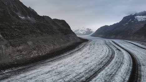 Flyover-over-the-longest-glacier-in-the-Alps---the-Aletsch-glacier-in-Valais,-Switzerland--from-side-to-side-on-a-cloudy-day