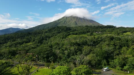 Aerial-view-moving-forward-shot,-Scenic-view-of-the-landscape-on-the-foothills-of-the-Arena-Volcano-in-Costa-Rica,-Lenticular-clouds-on-the-volcano-in-the-background