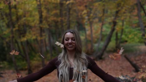 Beautiful-Blonde-Young-Woman-Tossing-Fall-Autumnal-Color-Leaves-in-the-Air