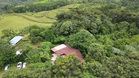 Aerial-view-moving-forward-shot,-Scenic-view-landscape-of-La-Tigra-Rain-Forest-in-Costa-Rica,-houses-in-the-background