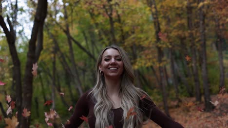 Beautiful-Happy-Blonde-Woman-Tossing-Autumn-Leaves-in-the-Air,-Slow-Motion