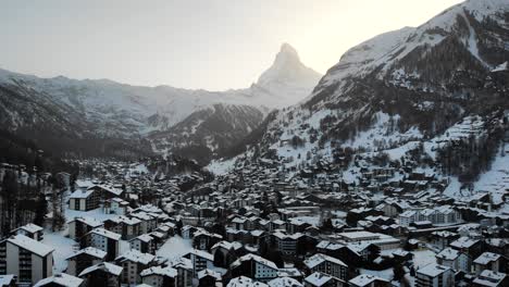 Aerial-flyover-over-Zermatt-with-pan-down-view-from-the-Matterhorn-to-the-city-at-sunset