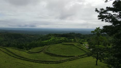 Aerial-view-moving-forward-shot,-above-the-trees-of-La-Tigra-Rain-Forest-in-Costa-Rica-reveal-a-Scenic-view-of-Landscape,-Cloudy-sky-in-the-background