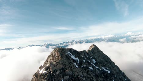 Aerial-drone-fly-over-gorgeous-mountain-tops-and-mountain-ridge-with-FPV-drone-close-to-aletsch-glacier,-Switzerland-above-clouds-with-spectacular-alpine-view