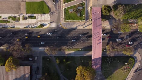 Aerial-top-down-view-of-busy-highway-underneath-overhead-pedestrian-bridge-crossing