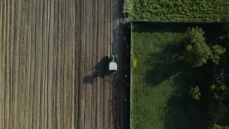 Antenne-Von-Oben-Nach-Unten-Eines-Traktors,-Der-Während-Des-Sonnenlichts-Landwirtschaftliche-Felder-In-Polen-Pflügt