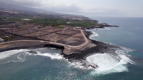 Las-Olas-Rompen-En-La-Costa-Rocosa,-La-árida-Costa-De-Tenerife,-La-órbita-De-Los-Drones