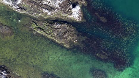 Aerial-footage-looking-down-onto-beautiful-Scottish-coastline-on-the-Isle-of-Arran-on-a-sunny-day