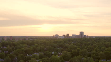 Slow-pull-back-away-from-Clayton-skyline-at-sunset-over-trees