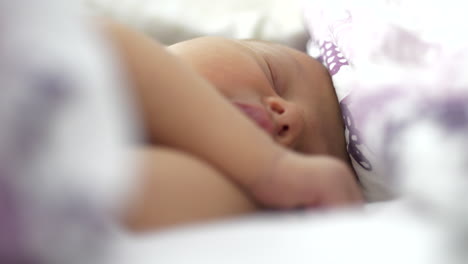 Just-born-baby-sleeping-sweet-on-white-cozy-bed,-close-up-view