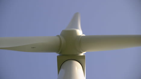 Close-upward-look-along-the-shaft-of-a-spinning-wind-turbine