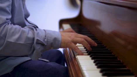Talentierter-älterer-Klavierkünstlermusiker-Spielt-Klassische-Musik-In-Blauem-Hemd-Und-Jeans-Nahaufnahme-Hände-Launische-Filmszene-Zeitlupe