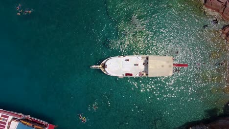Filmische-Drohnenaufnahme,-Die-Sich-In-Klarem-Wasser-Vom-Luxusboot-Distanziert