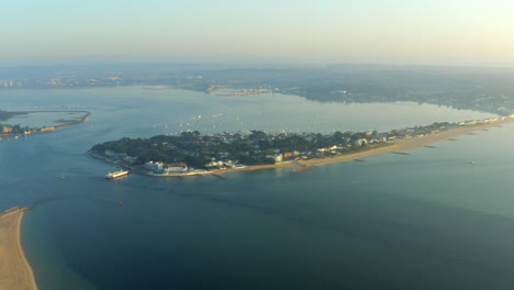 A-sweeping-aerial-shot-of-Sandbanks,-Brownsea-island-and-Poole-Harbour-on-English-coast-at-Golden-hour-in-the-British-summer