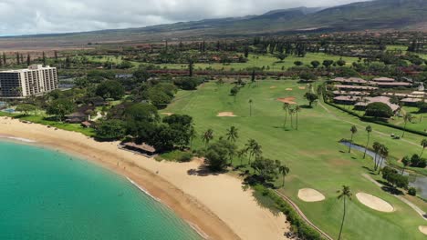 Rotating-aerial-view-of-the-Kaanapali-golf-course-over-May's-beach-in-maui,-Hawaii