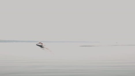Wasserfahrzeuge,-Die-Am-Ruhigen-See-Vor-Düsterem-Himmel-Vorbeifahren