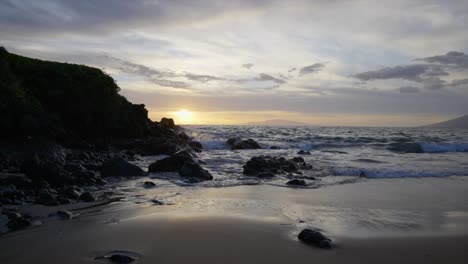 Lowering-slow-motion-scene-of-a-rocky-beach-at-sunset-in-Maui-Hawaii