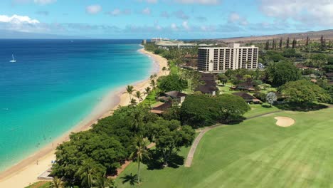 Luftaufnahme-Von-Weißen-Vögeln-über-Einem-Golfplatz-Und-Einem-Langen-Sandstrand-In-Maui,-Hawaii